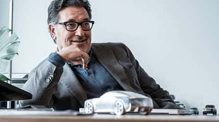 Porträt, Büro, Schreibtisch, Automodell, Designer, Interview, Mann, Brille, Modellauto, Gespräch Porträt eines Mannes im Büro, sitzend an einem Schreibtisch mit Automodell.