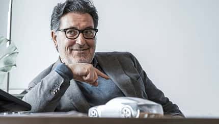 Porträt, Büro, Automodell, Schreibtisch, Designer, Massimo Fracella, Automobilbranche, Brille, Business, Interview Porträtaufnahme einer Person im Sakko an einem Schreibtisch mit einem Automodell im Vordergrund.